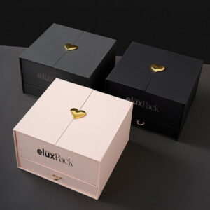 Three elegant luxury boxes, featuring gold heart accents and a drawer compartment, with a sleek and minimalist design. Two black boxes and one white box are displayed, perfect for high-end packaging or special gift presentations.