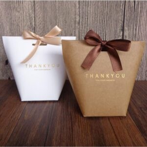 Two elegant gift boxes with ribbon closures, one in white with a gold ribbon and the other in kraft brown with a brown ribbon. Both boxes have the words "Thank You for Your Kindness" in gold foil on the front, ideal for special occasions.