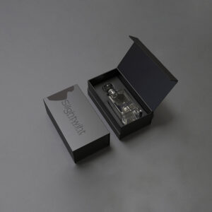 Luxurious black perfume box with magnetic lid, containing an elegant glass perfume bottle with a sleek design.