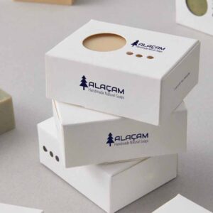 Handmade soap packaging with a minimalist white box and circular window for product display.